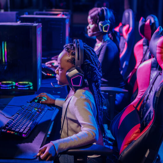 Beautiful young black mother and daughter playing online games in a Esports Gaming Cafe